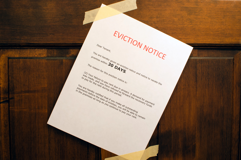 Eviction notice document taped to a front door in Dallas, Texas