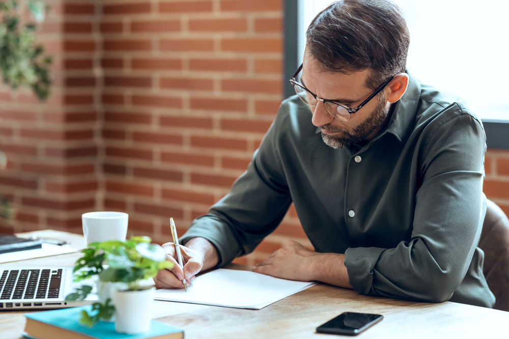 Landlord drafting an eviction notice for a tenant in Collin County, Texas, with paperwork on a desk.